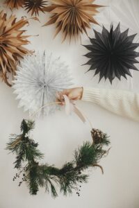 Handmade christmas decoratinion held in front of paper baubels